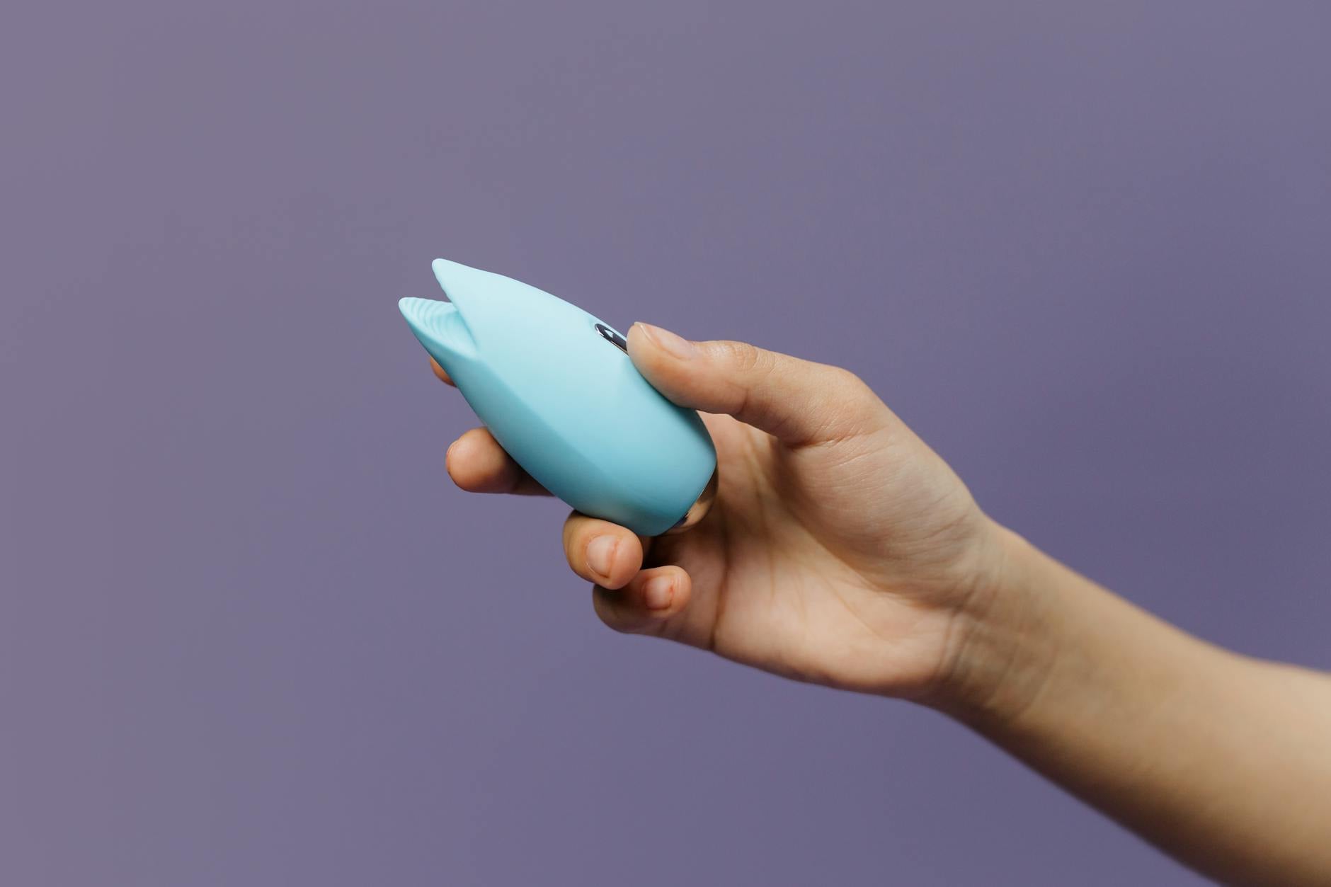 A lemon clitoral vibrator held gently in hand against a soft background